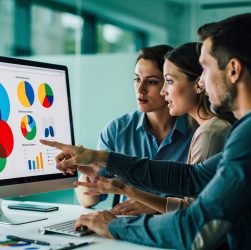 Équipe internationale dans un bureau moderne analysant des graphiques abstraits de performance web sur un écran, dans une ambiance professionnelle et réaliste.